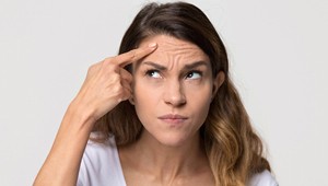 woman disliking her wrinkles and thinking about BOTOX