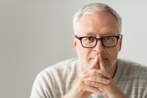 man folded hands glasses