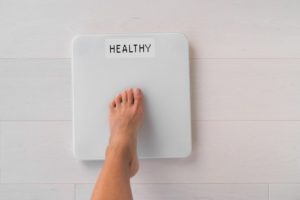 person stepping on the scale after medical weight loss without surgery