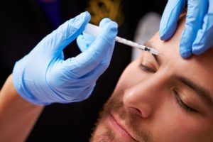 man getting a BOTOX injection between his eyes