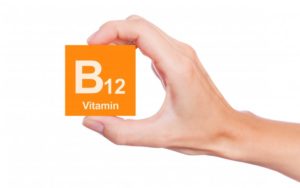 hand holding a block with Vitamin B12 on it