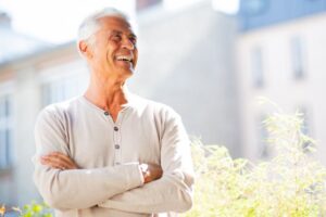 smiling older man outside with his arms folded